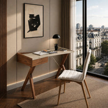 Load image into Gallery viewer, A modern home office setup featuring a wooden writing desk with a light top, a white upholstered chair, and a black desk lamp, set against a beige paneled wall with a large window overlooking a Parisian cityscape.